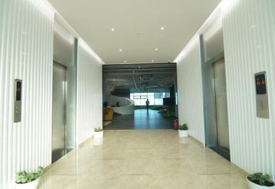 Bright white elevator lobby with fluted wall panels and marble flooring.