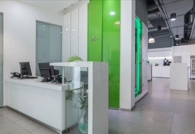 Clean, modern reception desk with glass partitions and bright green feature walls.