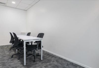 Small private office suite with a white table and black mesh chairs.