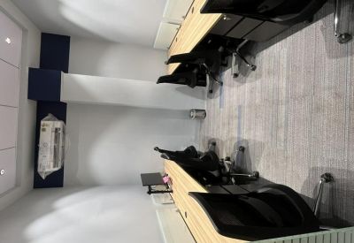 Compact private office space with wooden desks, black chairs, and navy blue wall accents.