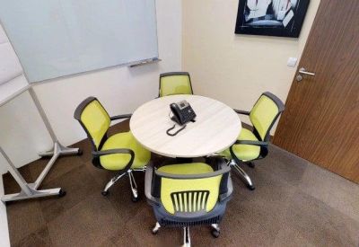 Four-person meeting pod with lime green chairs and a round table.