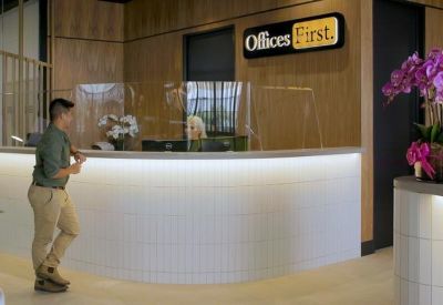 Modern reception desk with bright under-counter lighting and purple orchid decorations.