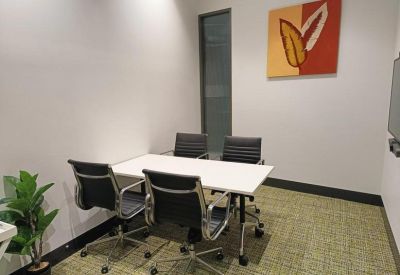 Private four-person meeting room with a white table and modern art on the wall.