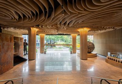 Grand lobby featuring a dramatic undulating wooden ceiling and polished stone floors.