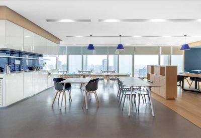 Communal dining area with modern seating and blue hanging lights.