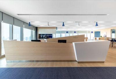 Reception area with a modern front desk and wooden flooring.