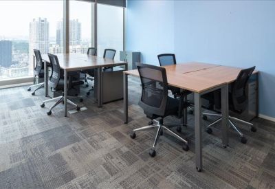 Open office space with multiple desks and large windows.