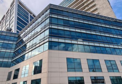 Close-up of the modern glass facade and white tile exterior of the building.