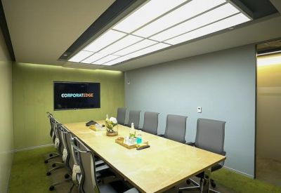 Modern meeting room with a large wooden table and light panel ceiling.