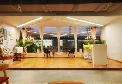 Bright break-out area with wooden floors and floor-to-ceiling windows.