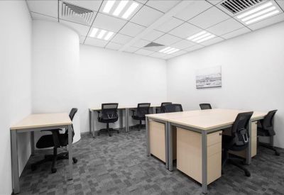 Spacious open-plan workspace with multiple desks and ergonomic black chairs.