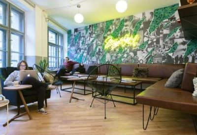 Trendy breakout area featuring a vibrant wall mural, neon signage, and comfortable leather seating.