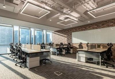 Open-plan office space featuring industrial brick walls and modern workstations.