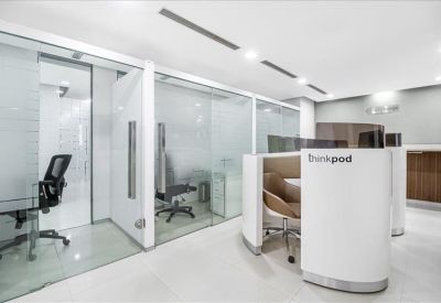 Communal coworking area featuring private glass booths and branded 'thinkpod' stations.