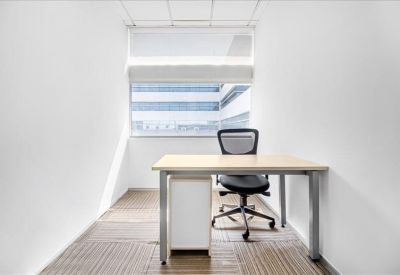 Bright private office suite with a wooden desk and large window.