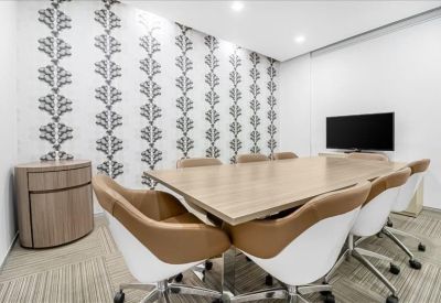 Boardroom with a long wooden table, patterned feature wall, and wall-mounted TV.