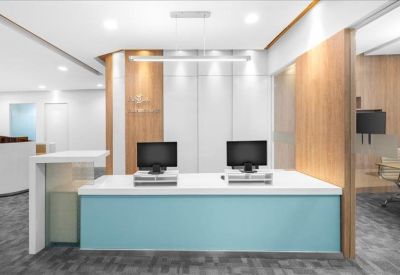 Reception desk with a light blue front panel and dual monitors.
