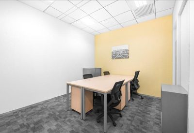 Private internal office with a light wood desk and yellow feature wall.