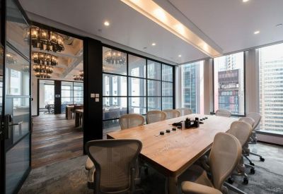 Large meeting room with a wooden table, ergonomic chairs, and a glass partition wall.