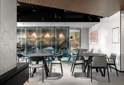 Dining area with round tables and a mix of grey and blue chairs.