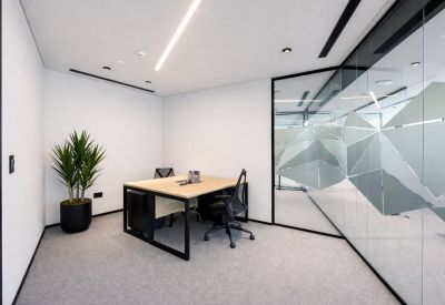 Private office suite with a wooden desk and frosted glass partition.