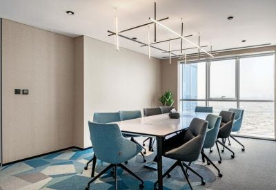 Modern boardroom with geometric pendant lighting and blue chairs.