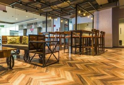 Cozy reception or lounge area with herringbone wood floors and rustic furniture on wheels.