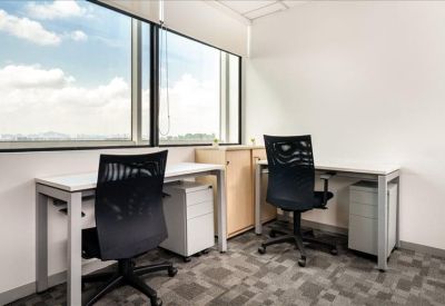 Bright private office suite with two desks and large windows overlooking the city.