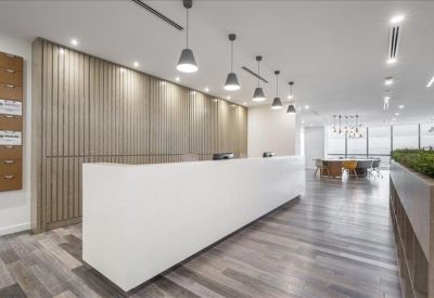 Minimalist white reception desk with wood-paneled walls and hanging pendant lights.