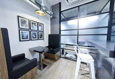 Cozy communal breakout booth with padded seating and framed wall art.