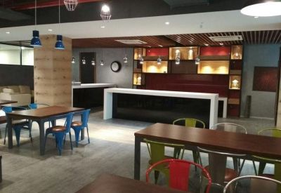 Bright dining area with dark wood tables, blue chairs, and a red-accented storage unit.