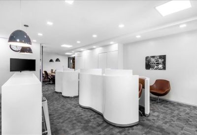 Bright coworking area with unique curved white privacy partitions and leather armchairs.