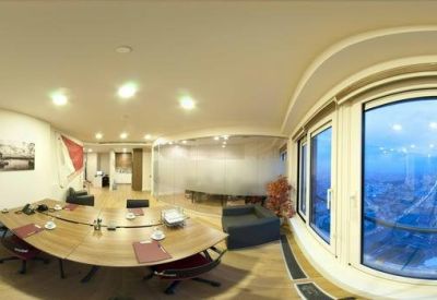 Large meeting room with an oval wooden table and panoramic city views.