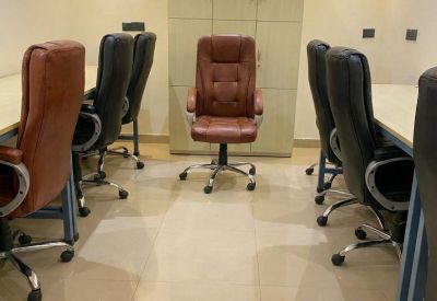 Professional workspace layout with desks and brown high-back chairs.