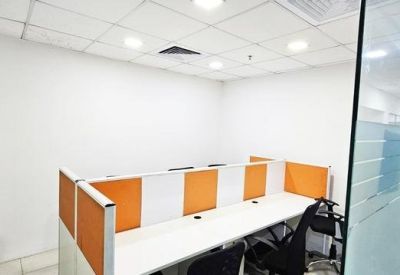 Compact workstation area with orange privacy dividers and a glass wall entrance.