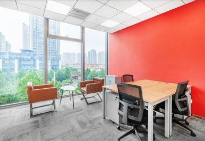 Private office with two desks and a bright red feature wall.