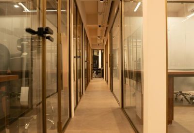 Perspective view of a long office corridor with glass-fronted office suites.