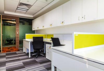 Private office suite featuring white desks, black chairs, and yellow privacy screens.