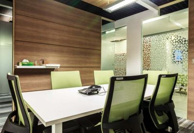 Small meeting room with lime green chairs and a wooden feature wall.