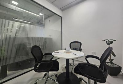 Small private meeting pod with a round white table and four black chairs.