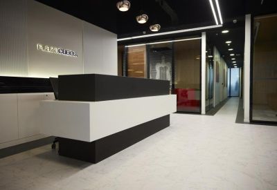 Sleek minimalist reception area with a black and white front desk and designer pendant lamps.