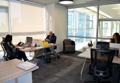 Modern three-person office suite with natural light and ergonomic chairs.