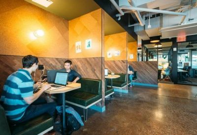 Breakout area featuring green leather booths and wood-paneled walls.