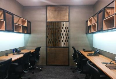 Symmetrical workspace with wooden desks and integrated storage cabinets.