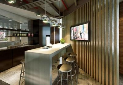 Communal kitchen area with a sleek metallic island bench and vertical wood slat feature wall.