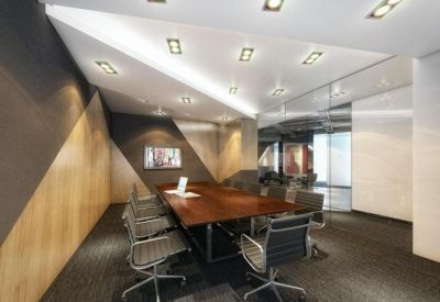 Modern meeting room with a large wooden table and geometric ceiling panels.