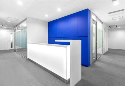 Modern minimalist reception desk with a vibrant blue accent wall.