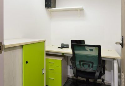 Small private office suite with a single desk, green storage cabinet, and carpeted floors.