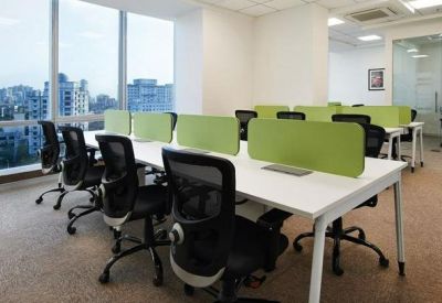 Spacious open-plan office with lime green desk dividers and large windows offering city views.