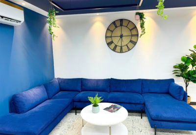 Modern lounge area with a large blue sectional sofa and a round coffee table.